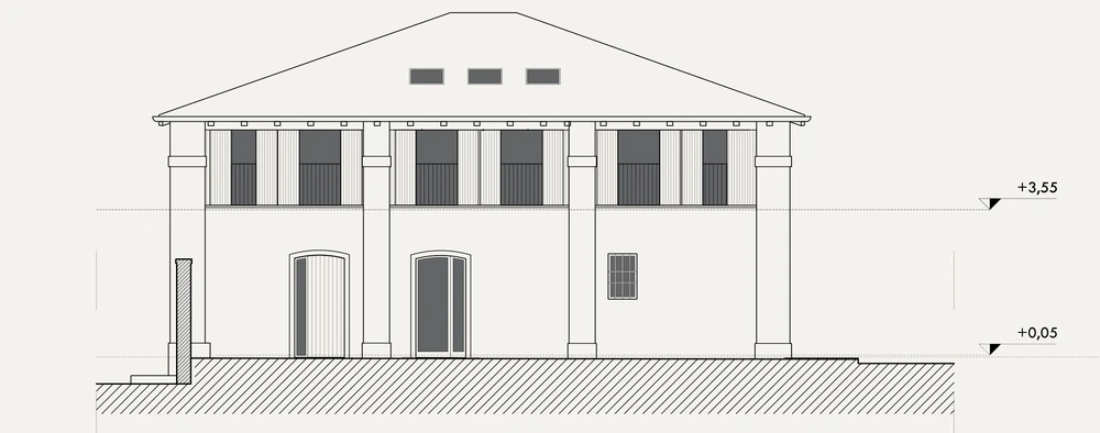 South elevation of building B: arched openings on the ground floor and timber-slatted openings above, between plastered piers under a hipped roof