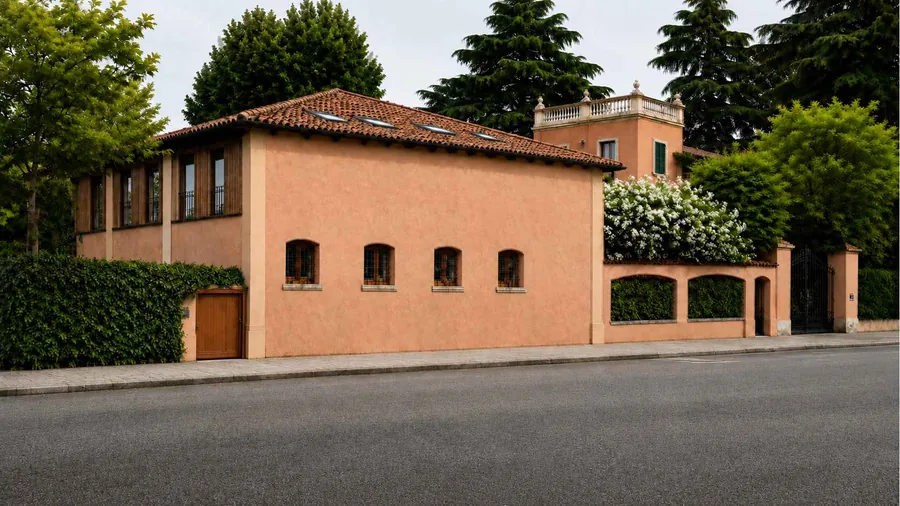Building B as designed: the same building re-rendered in warm ochre, with small arched windows behind wrought-iron grilles and a timber gate in the garden wall